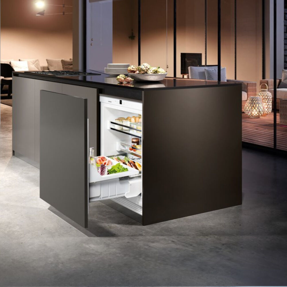 Built-in undercounter refrigerator drawer pulled out in modern kitchen island with organized fresh food storage