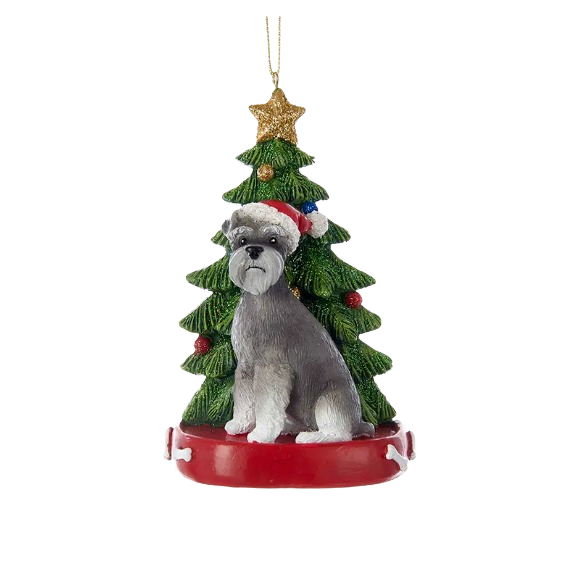 Festive schnauzer ornament wearing Santa hat in front of decorated Christmas tree with gold star topper