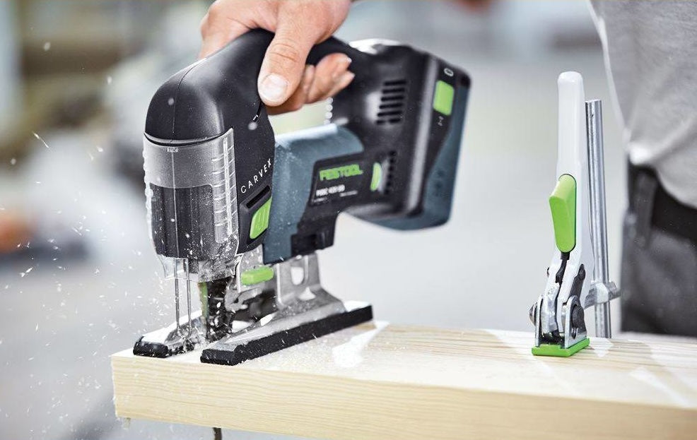 Cordless jigsaw cutting wood plank with clamps in a home improvement and power tools setting