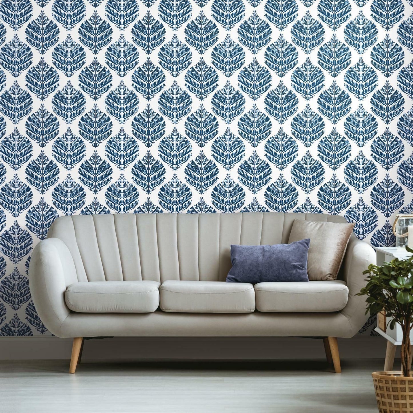 Blue fern damask pattern wallpaper in cozy living room setting with modern beige sofa and decorative pillows under 50 decor