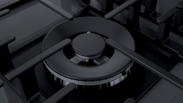Close-up of dark silver tempered glass cooktop burner with enamelled heavy-duty grates for cooktops and home improvement