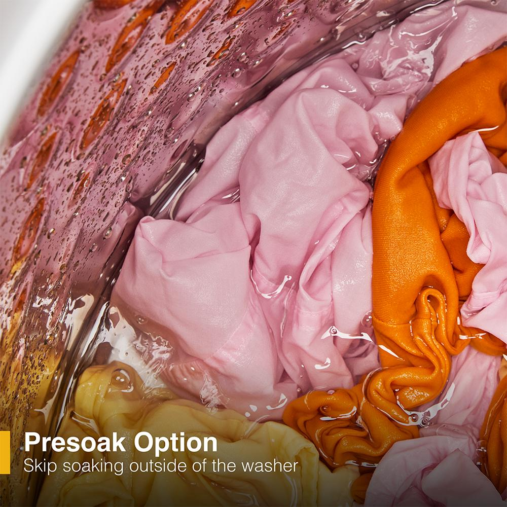 Close-up of colorful clothing soaking inside a top load impeller washer with water for presoaking cycle in appliance collection