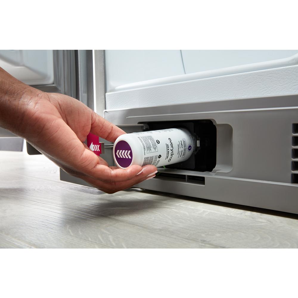 Hand inserting water filter cartridge into base of a 36-inch side-by-side refrigerator in Appliances collection