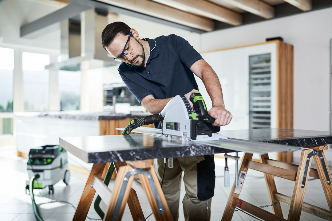 Man using Festool power tool connected to Festool 577872 CLEANTEC CT 36 EI HEPA Dust Extractor for woodworking tasks