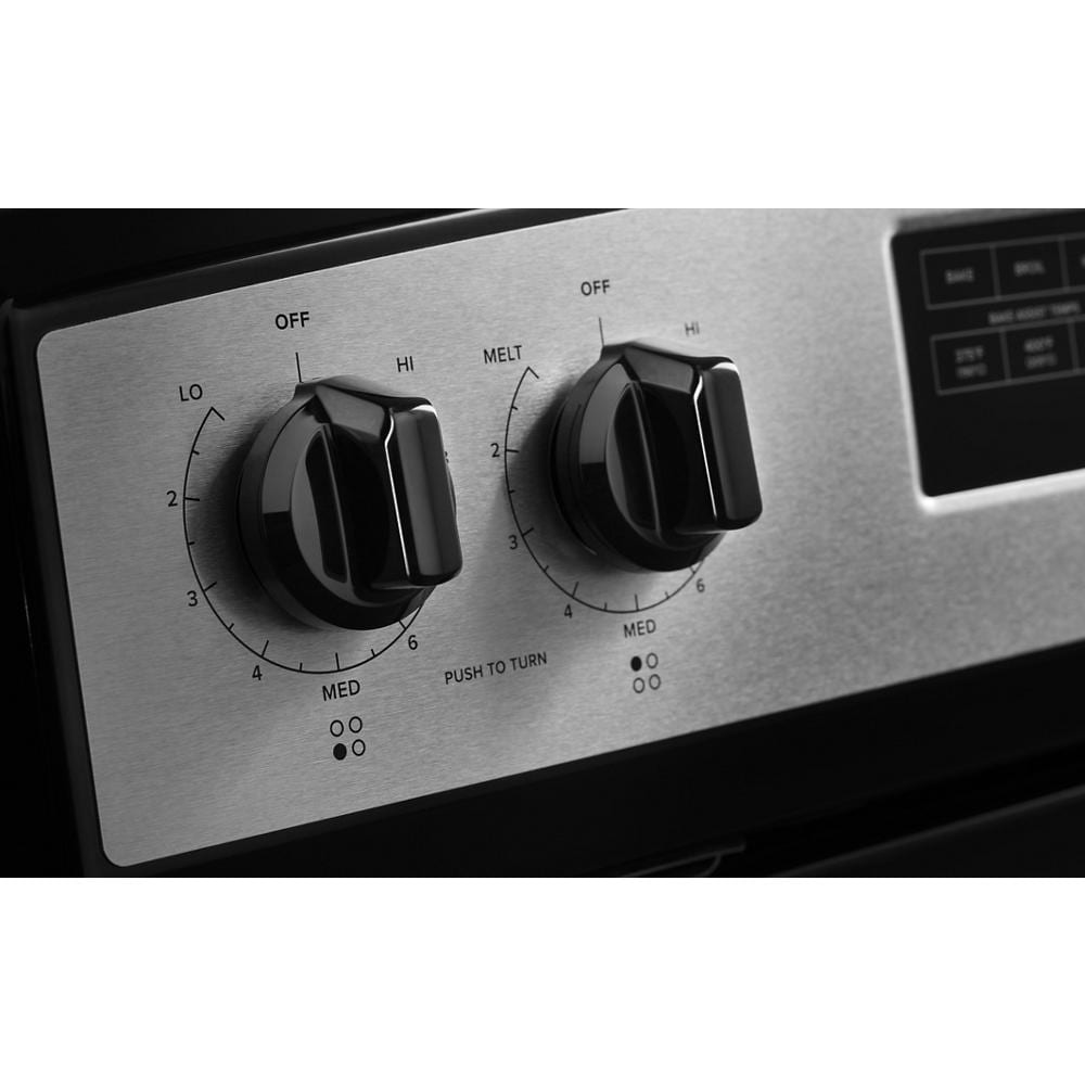 Close-up of black control knobs on stainless steel panel showing temperature settings for electric range burner and warming zone functions