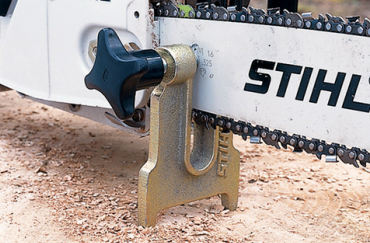 Compact metal stump vise securing chainsaw guide bar for stable sharpening in saw accessories and home improvement tools