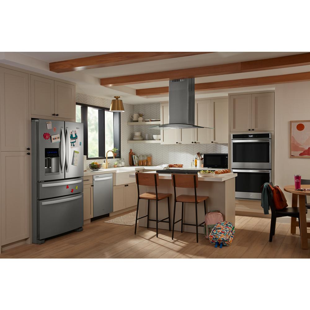 Modern kitchen featuring stainless steel appliances with a curved glass island mount range hood from Island Range Hoods collection