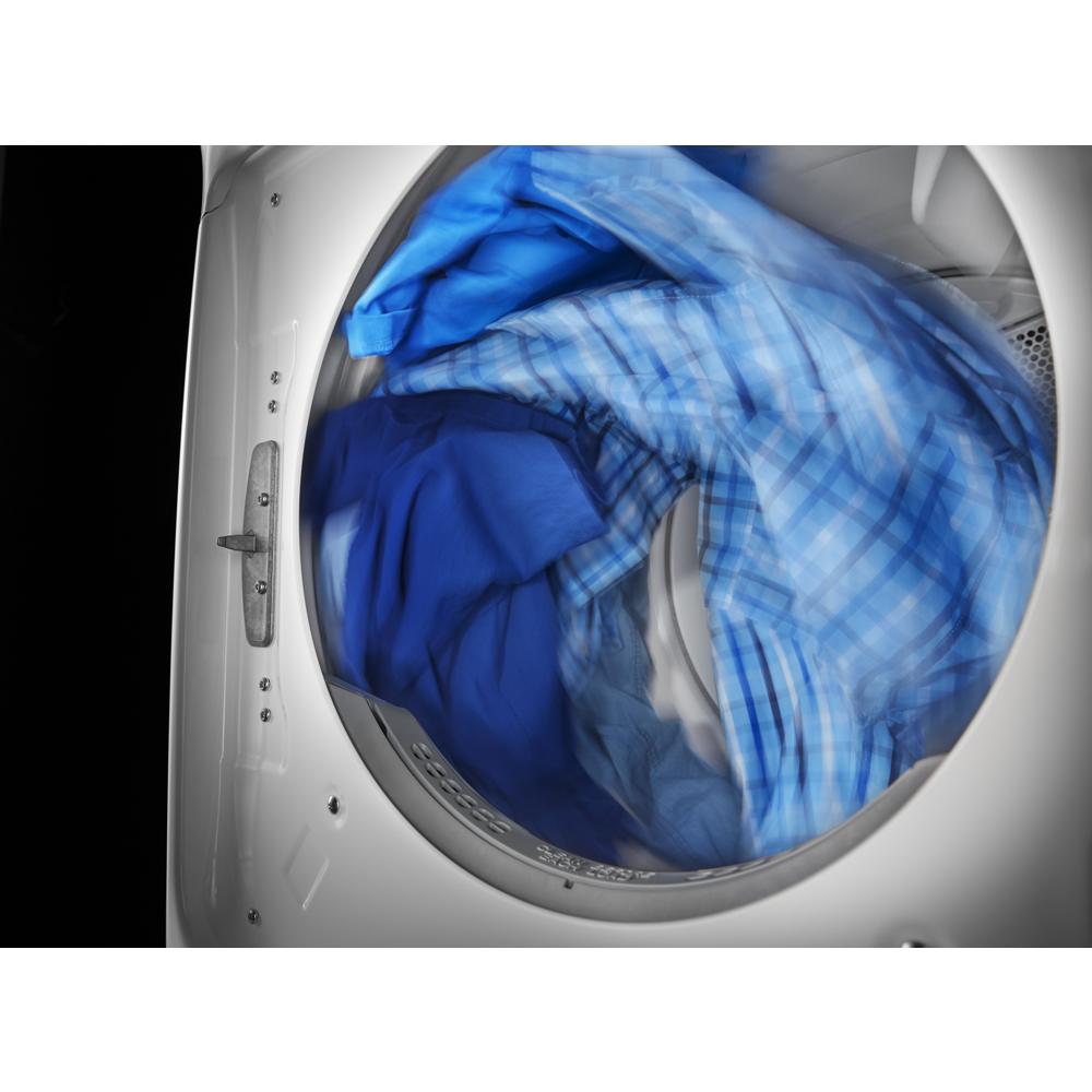 Front load electric dryer drum with motion blur showing blue clothes tumbling inside from Dryers collection
