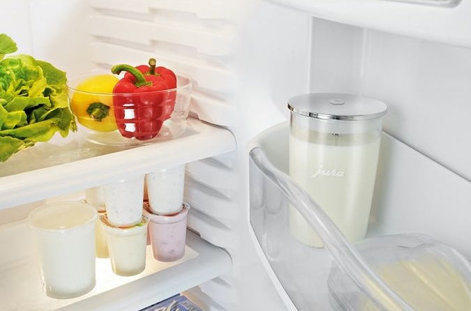 Clear glass milk container with silver lid stored in refrigerator door from kitchen gadgets and tools collection