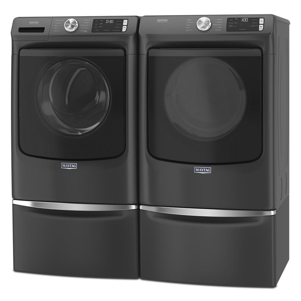 Sleek black front load washer and gas dryer pair with digital controls and matching pedestal storage in modern appliance setup