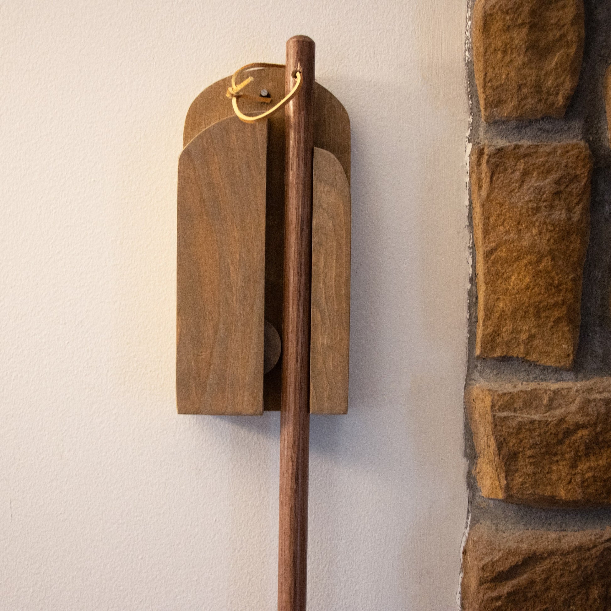 Wall-mounted wooden broom holder in warm tones, ideal for cleaning tools and home improvement under $50 collections