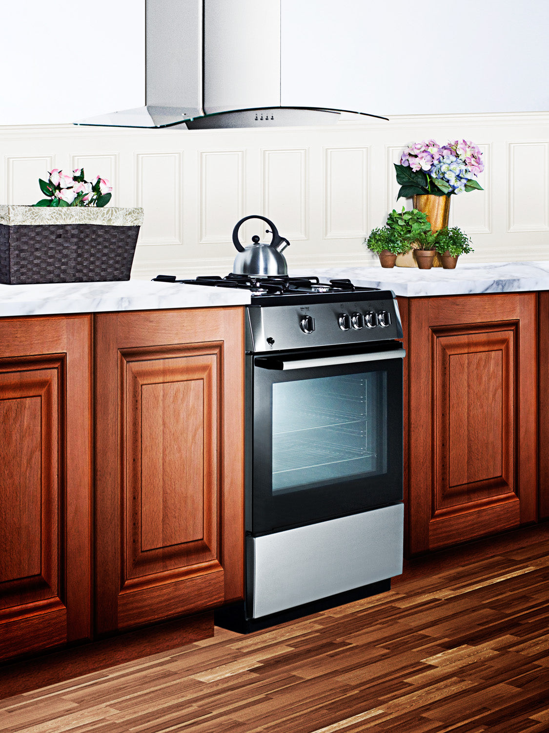 Modern 24-inch stainless steel gas range with four burners and oven, set in kitchen with wood cabinets and marble countertops