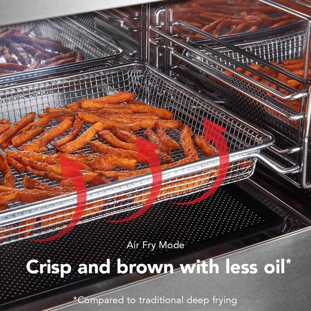 Crispy sweet potato fries in a metal air fryer basket inside stainless steel convection microwave oven with Air Fry mode.