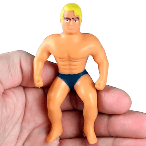 Small flexible action figure with muscular build and blonde hair held in a person’s hand for scale.