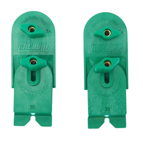 Two green plastic ramp clamps with brass threaded inserts and adjustable locking wedges for woodworking tools use