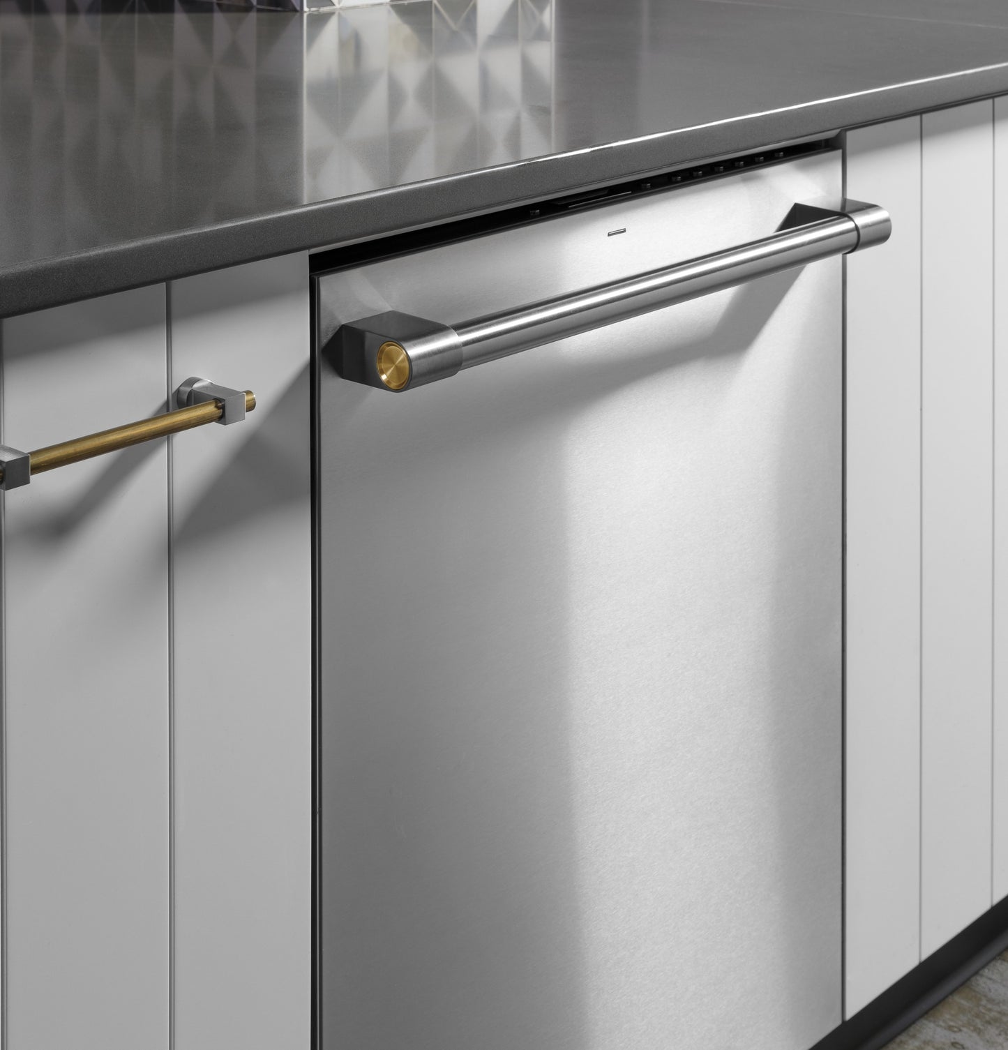 Stainless steel built-in dishwasher with sleek handle integrated into modern kitchen cabinets and countertop surface