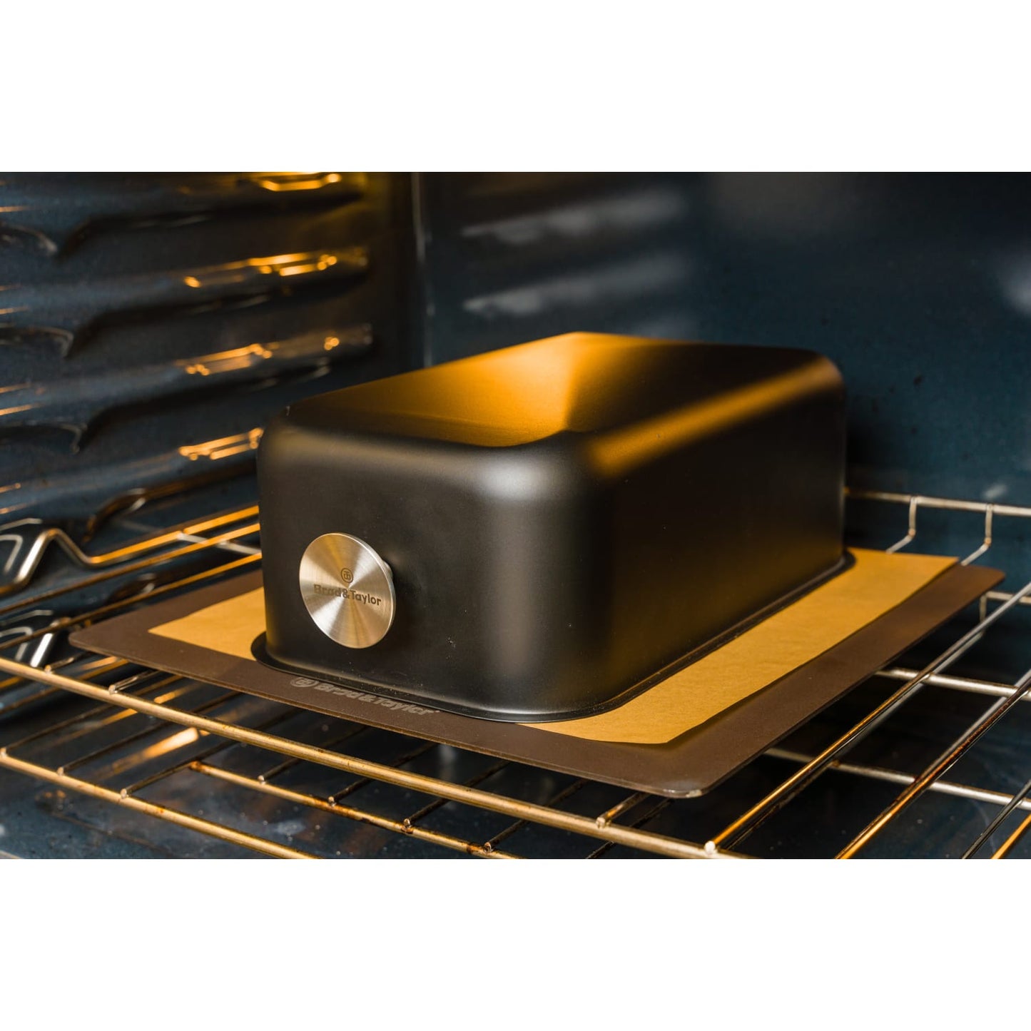 Black baking shell with stainless steel accent inside oven on baking sheet for kitchenware and bakeware collections under 100