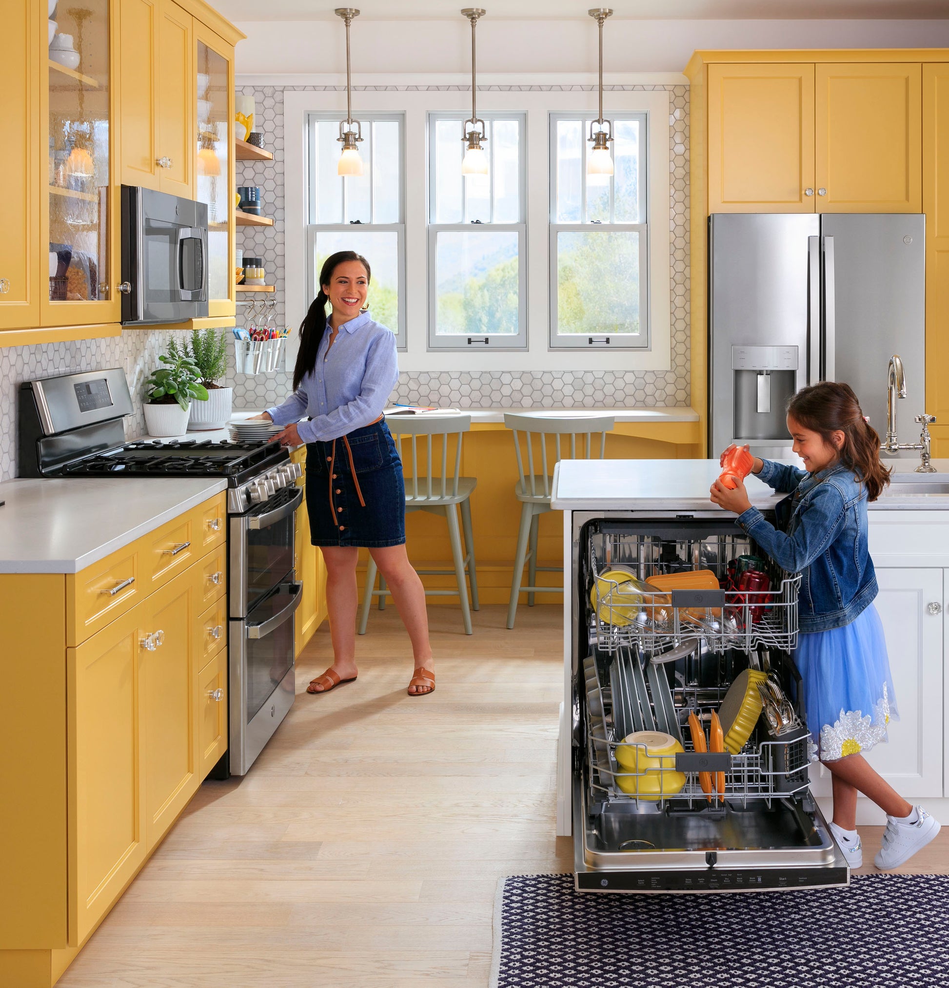 Kitchen with bright yellow cabinets featuring a fingerprint resistant sensor microwave and stainless steel appliances in a modern home