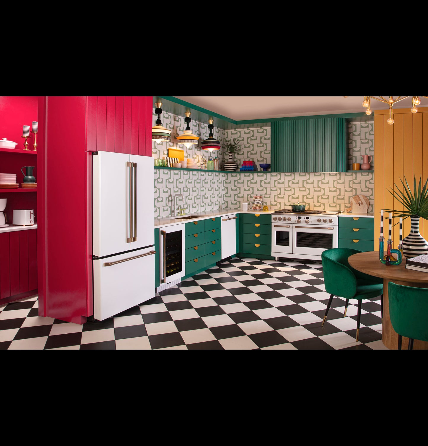 Colorful kitchen with checkered black and white tile floor, teal and red cabinetry, gold accents, and modern appliances