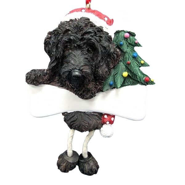 Dark brown Labradoodle dog ornament wearing Santa hat with dangling legs and small decorated Christmas tree holiday décor