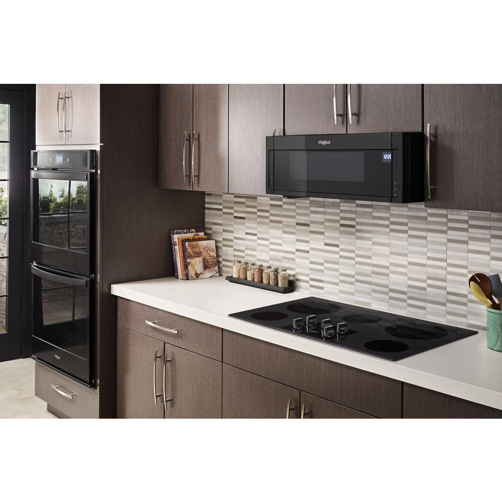 Modern kitchen setup with black electric cooktop, built-in oven, microwave, and brown cabinetry for home improvement.