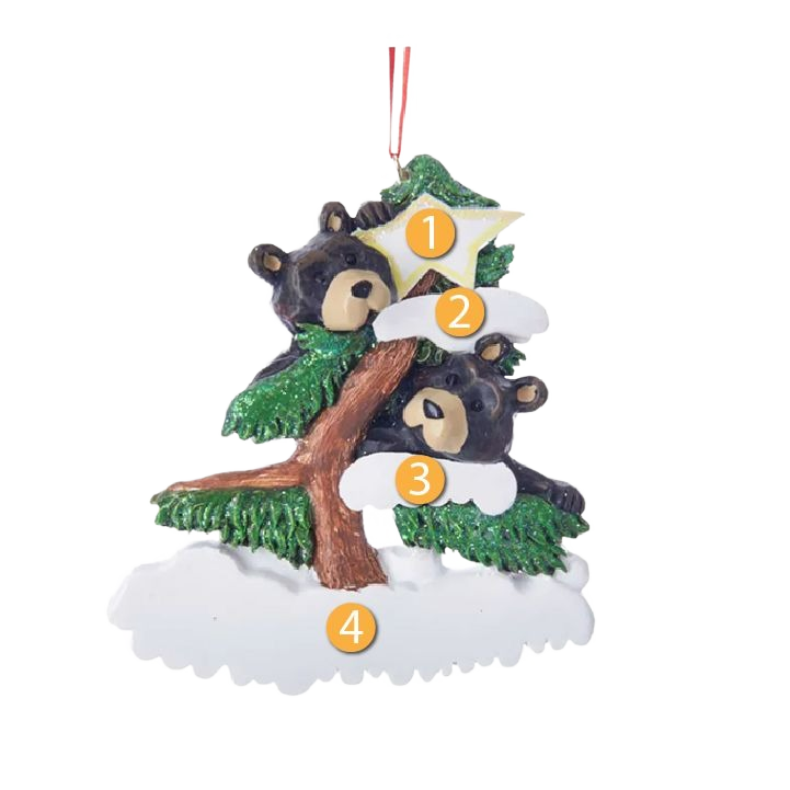 Decorative ornament featuring two black bears peeking from a snow-covered tree with green branches and a hanging loop