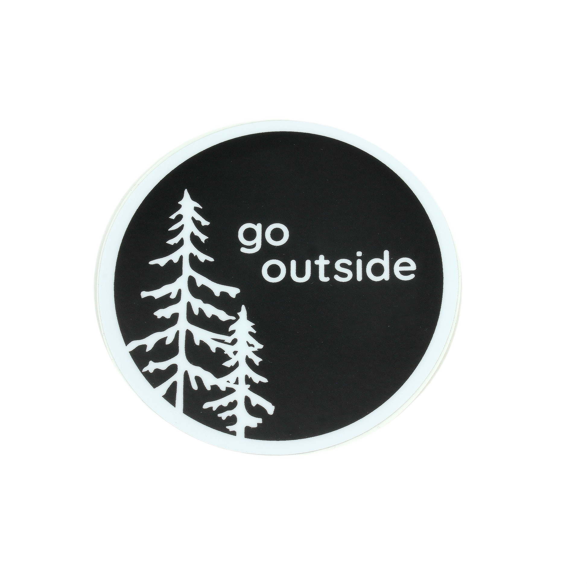 Round black sticker with white silhouettes of pine trees and the words go outside in simple font