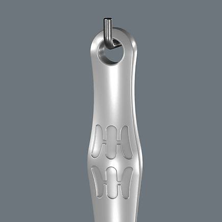 Close-up of silver metal spanner handle with embossed grip pattern hanging on hook for tools and home improvement use