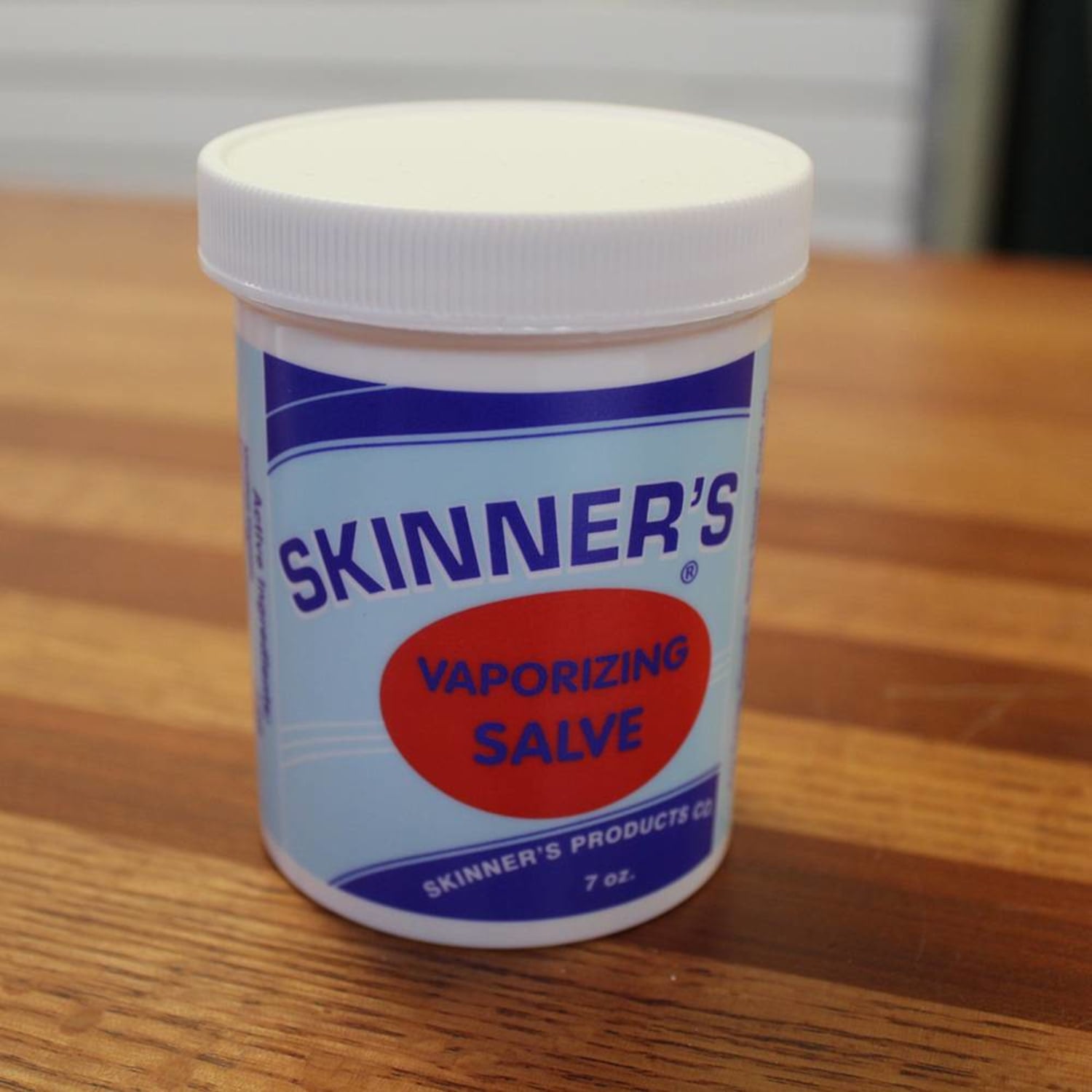 White plastic jar of Skinner's Vaporizing Salve with blue and red label on wooden surface in Health & Beauty under $50 collection