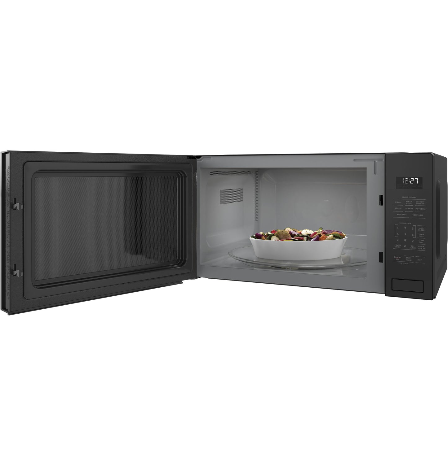 Black built-in microwave with open door revealing white interior and bowl of mixed vegetables inside kitchen appliance collection