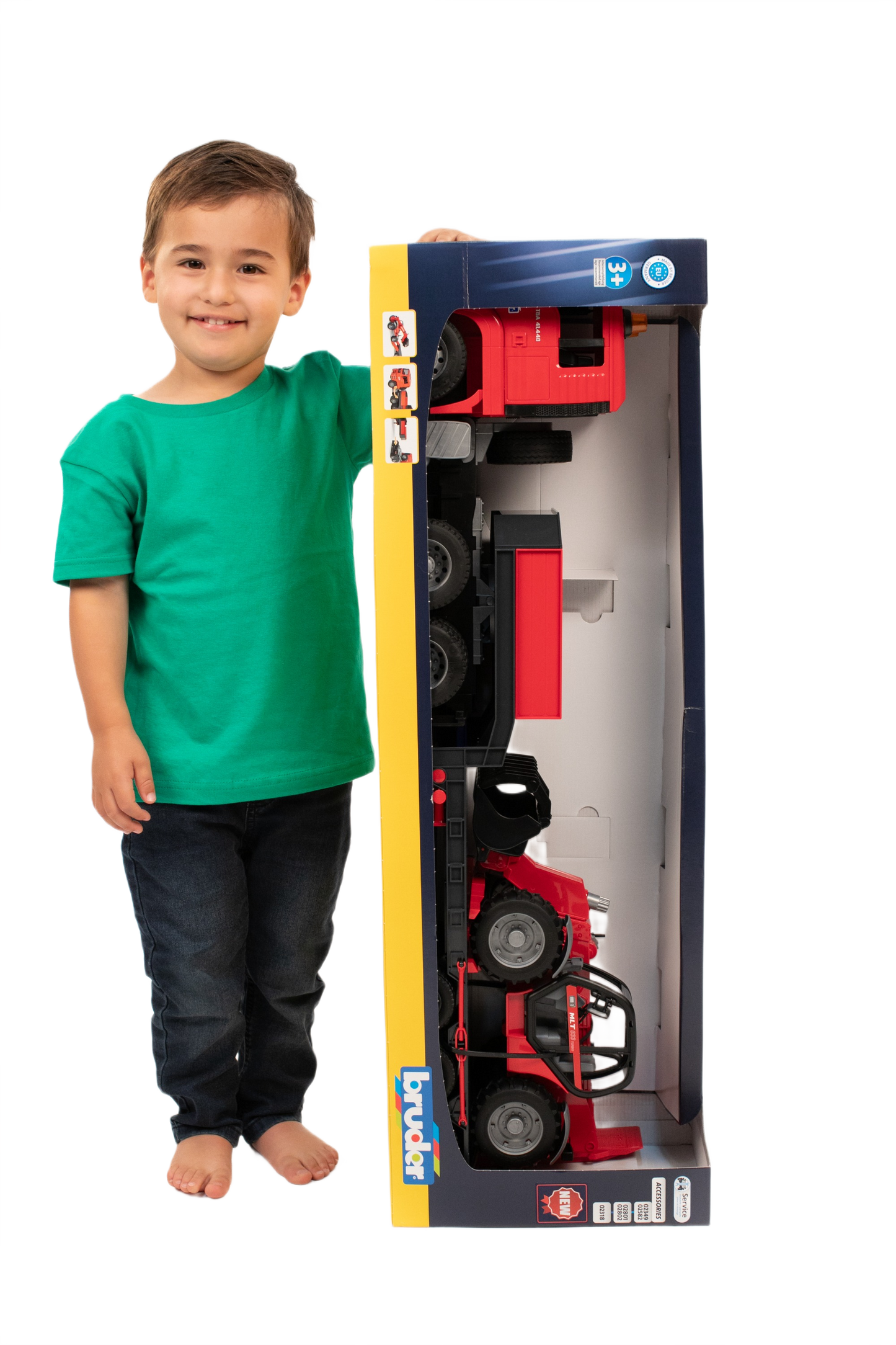 Young child in green shirt standing next to boxed red Bruder MAN TGA loader truck toy with Manitou loader inside
