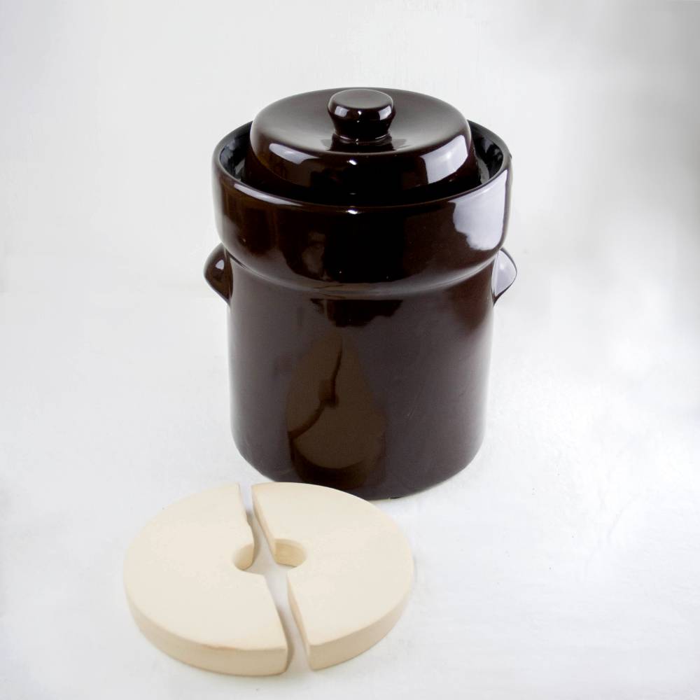 Glossy dark brown ceramic fermenting crock with separate lid and two-piece airlock weight on white background
