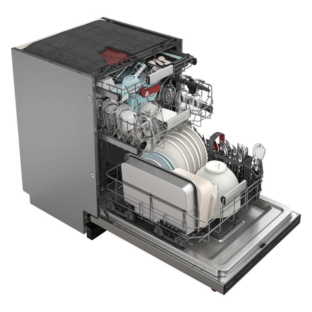 Open dishwasher with three racks fully loaded with dishes, utensils, and cookware in KitchenAid appliances collection