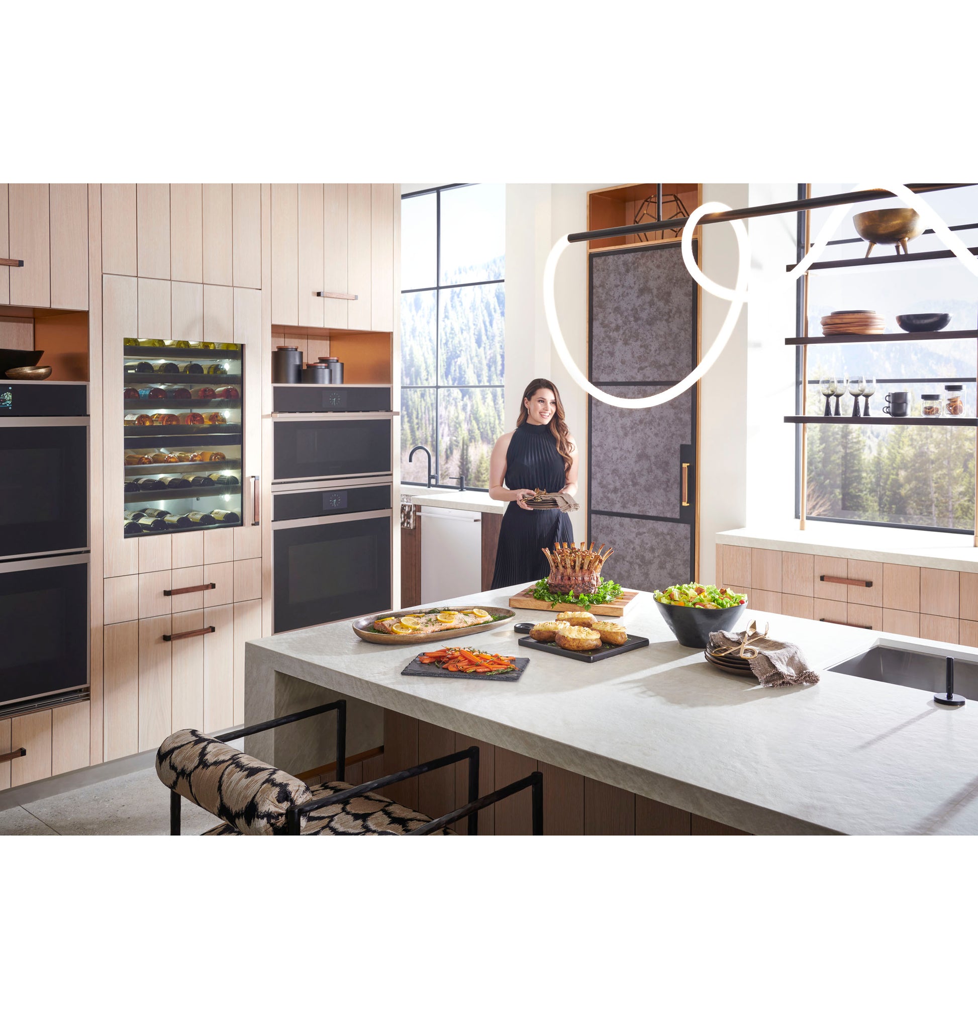 Modern kitchen with minimalist double wall ovens, light wood cabinetry, large island, and scenic window view in appliances collection