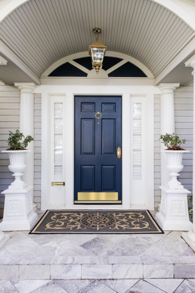 Brushed gold aluminum kickplate on dark blue front door with decorative hardware in door accessories under $100 collection