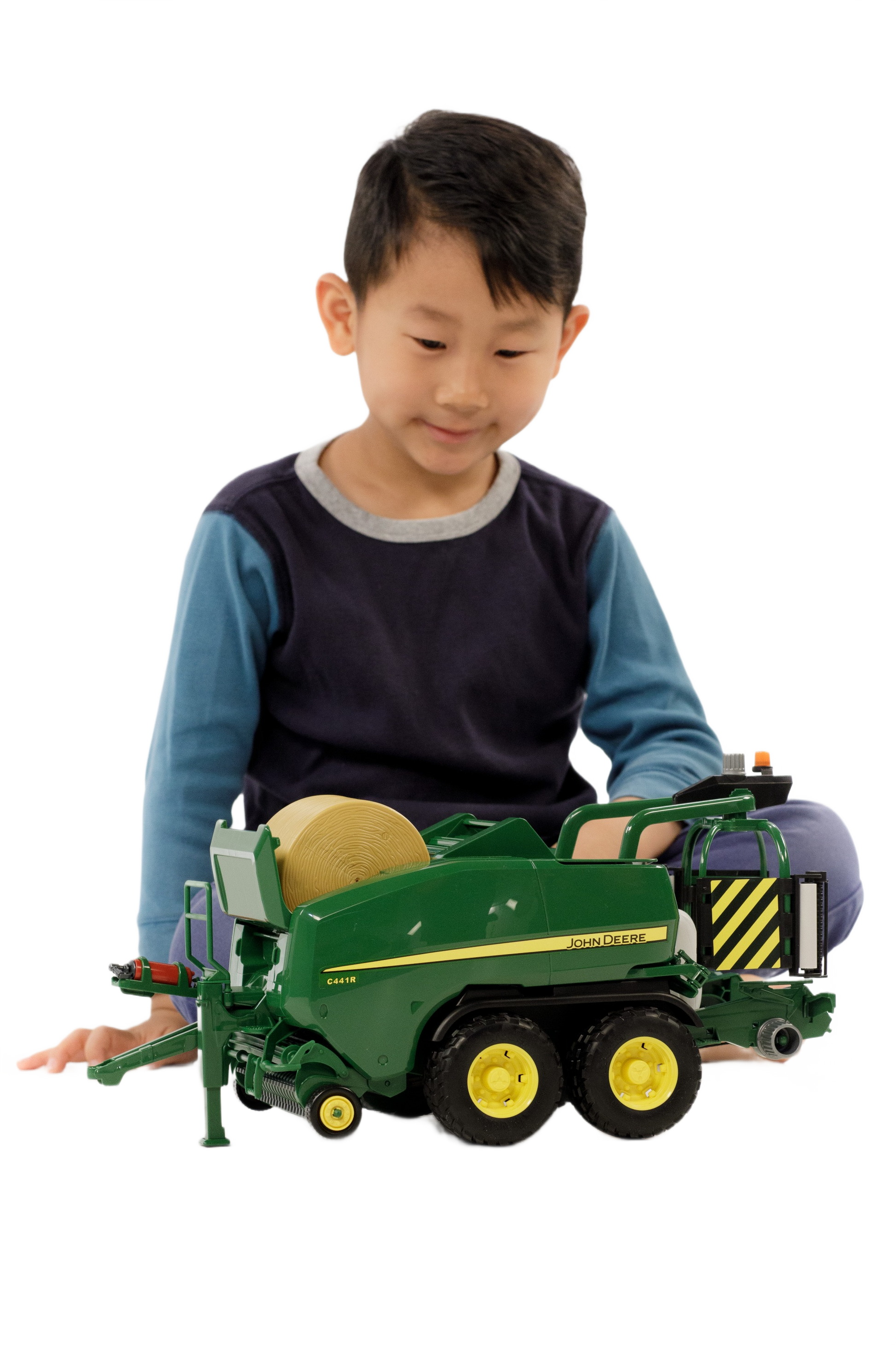 Child playing with green and yellow John Deere toy baler from Bruder Toys in Vehicles & Remote Controlled Toys collection