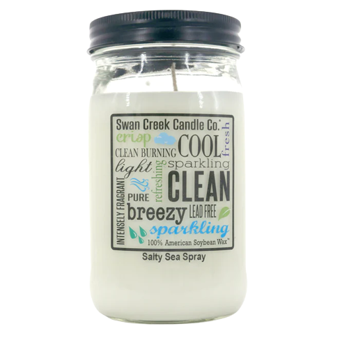 Clear white soy wax candle in glass jar with black lid labeled with fresh, clean, and breezy sea spray scent details