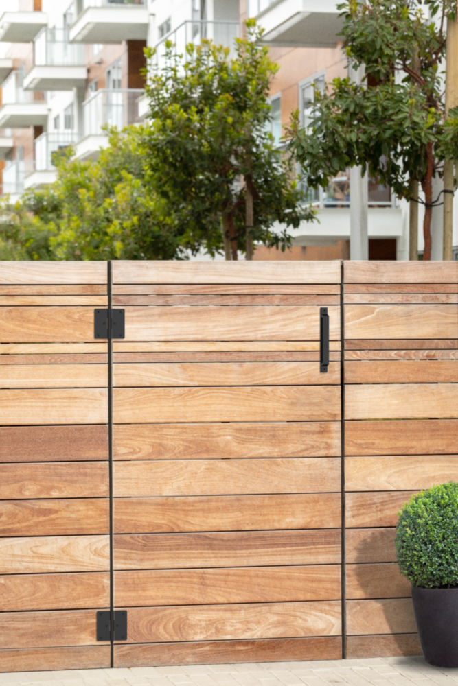 Modern black gate pull with WeatherGuard finish on wooden gate for durable home improvement and outdoor hardware projects