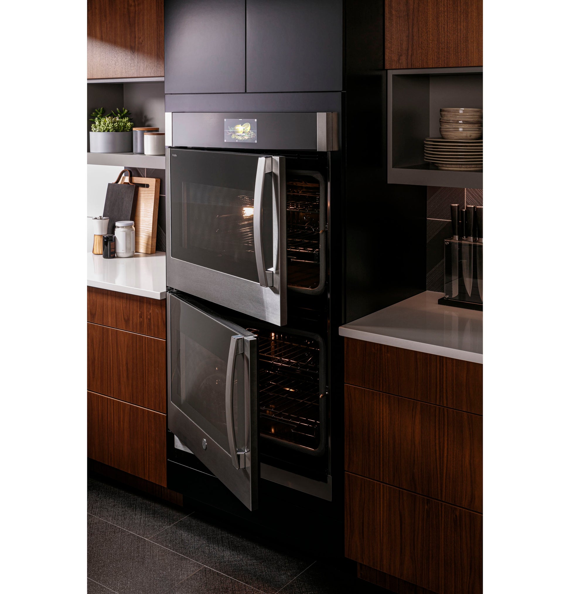 Built-in double wall oven with right-hand side-swing doors in modern kitchen with wood cabinetry and appliances