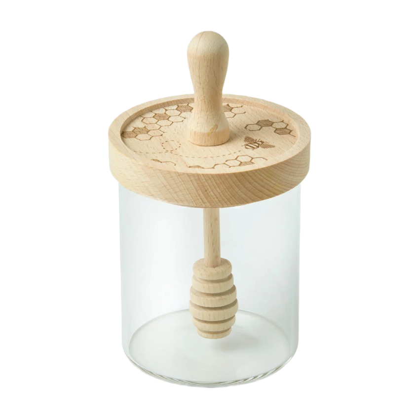 Glass honey jar with engraved wooden lid and matching honey dipper in countertop storage collections