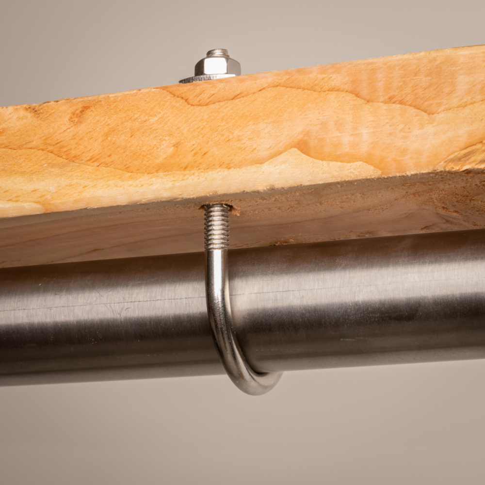 Metal U bolt with nuts securing a pipe to a wooden beam for hardware, fasteners, and home improvement projects