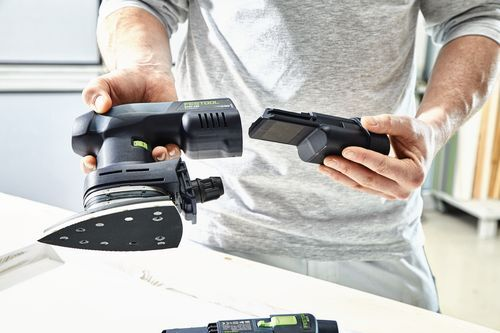 User holding a cordless delta sander and detachable battery for tools and home improvement tasks