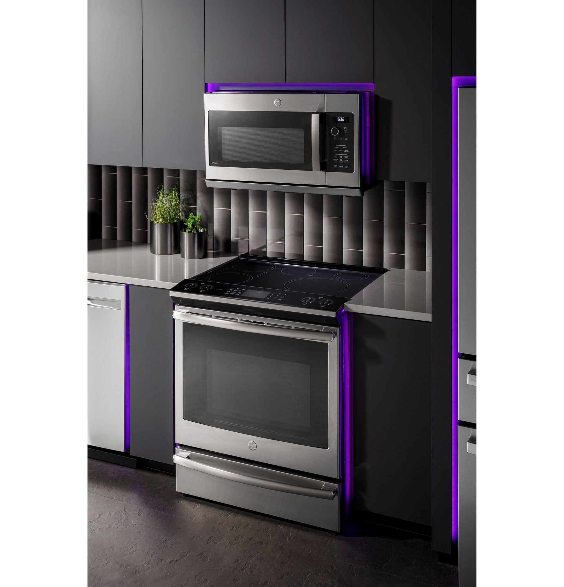 Modern kitchen featuring stainless steel over-the-range microwave and electric stove with sleek dark cabinetry and tile backsplash