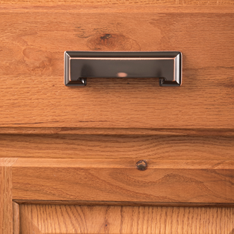 Oil-rubbed bronze center-to-center cabinet pull mounted on natural wood surface for home improvement projects
