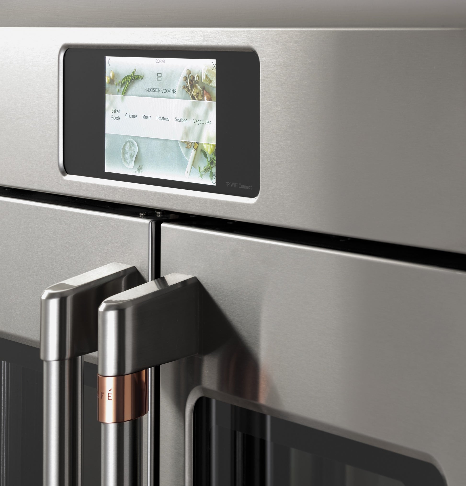 Close-up of stainless steel double wall oven doors with touchscreen control and sleek handles in modern kitchen appliance