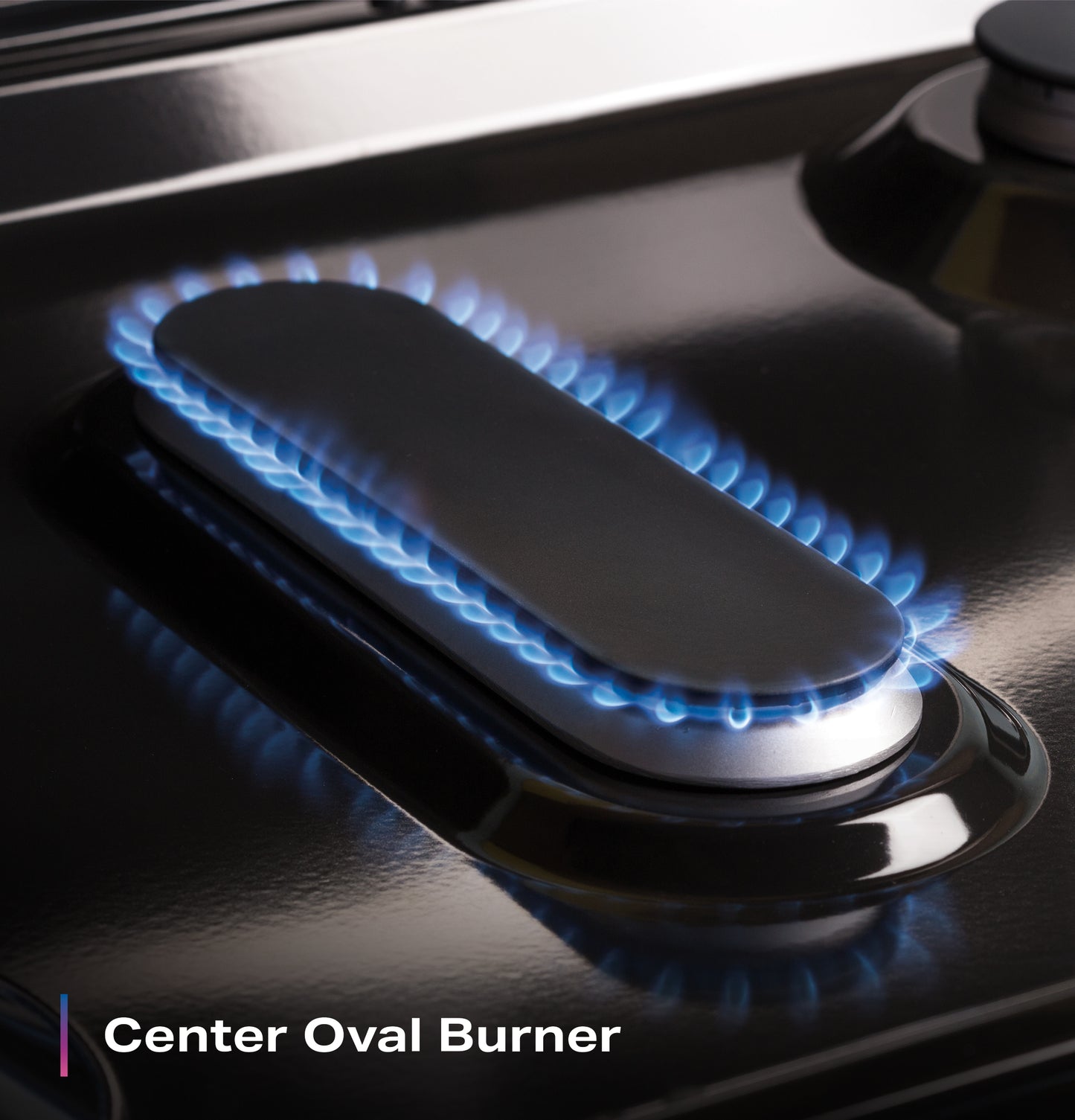 Oval-shaped gas burner with blue flames on a glossy black surface in kitchen appliances and ranges collection