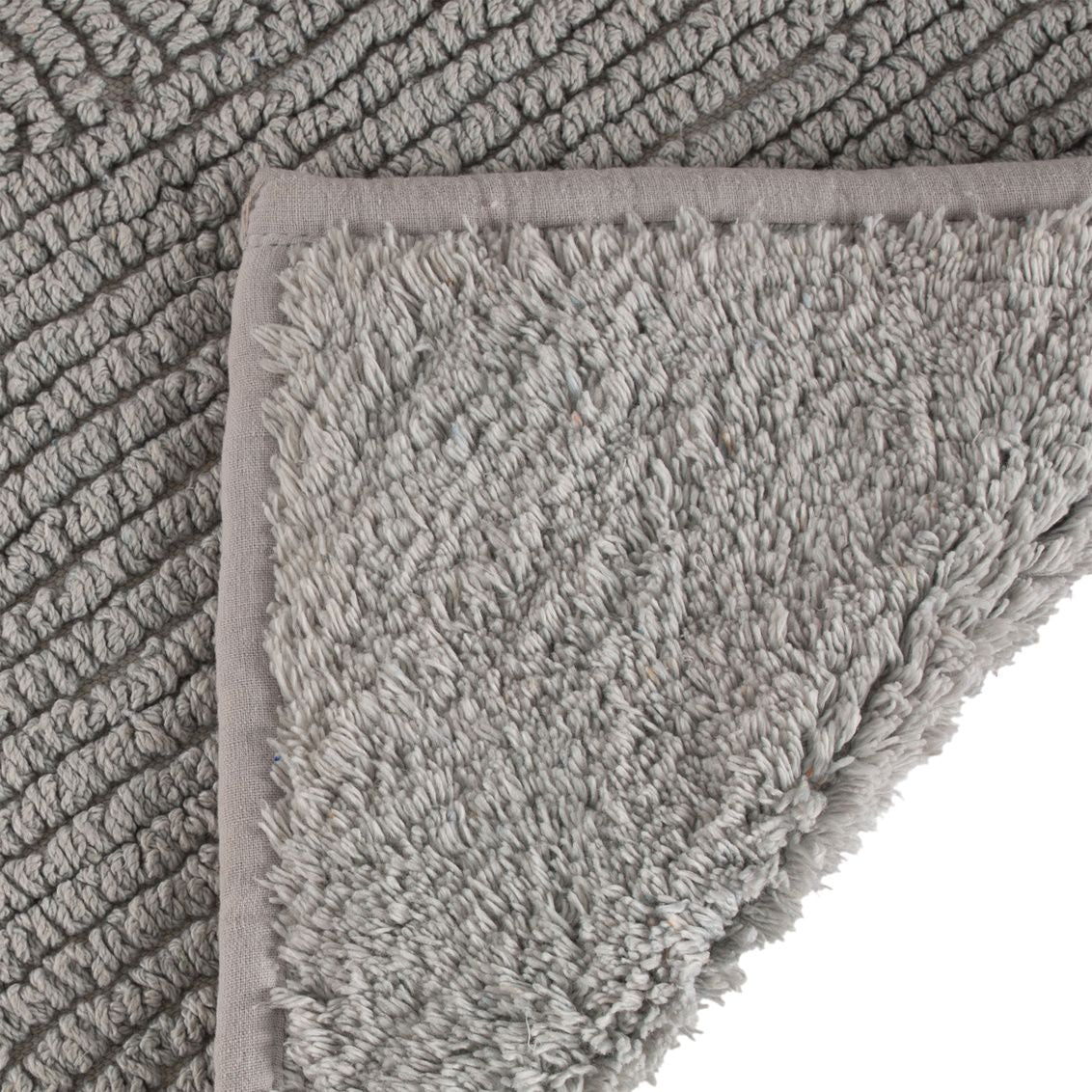 Close-up of gray reversible bath mat with plush texture and mid-century inspired design for bathroom comfort and safety