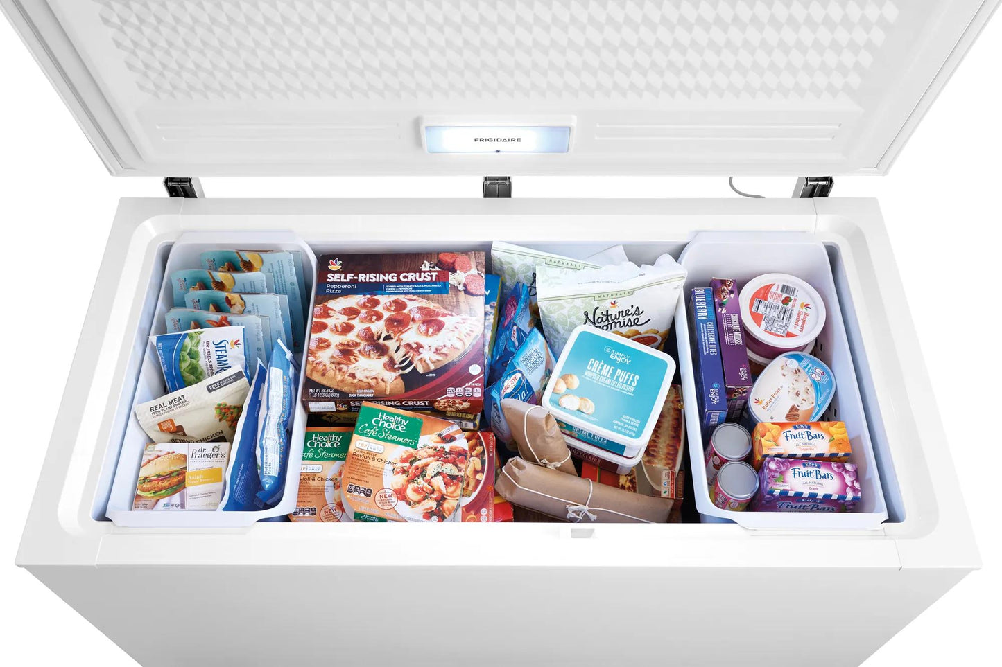 Open white chest freezer filled with frozen pizzas, desserts, and various packaged foods in kitchen appliance collections