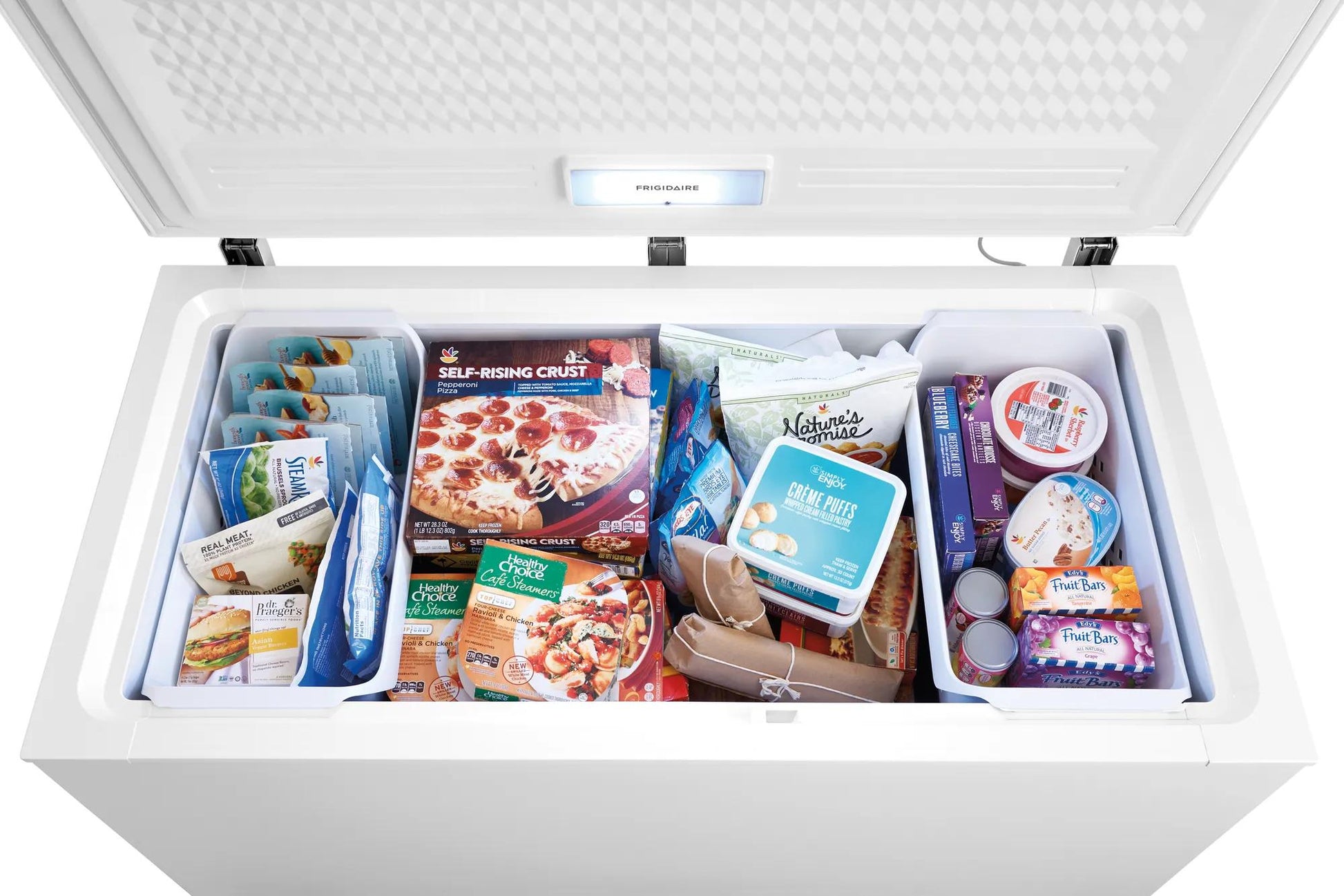 Open white chest freezer filled with frozen pizzas, desserts, and various packaged foods in kitchen appliance collections