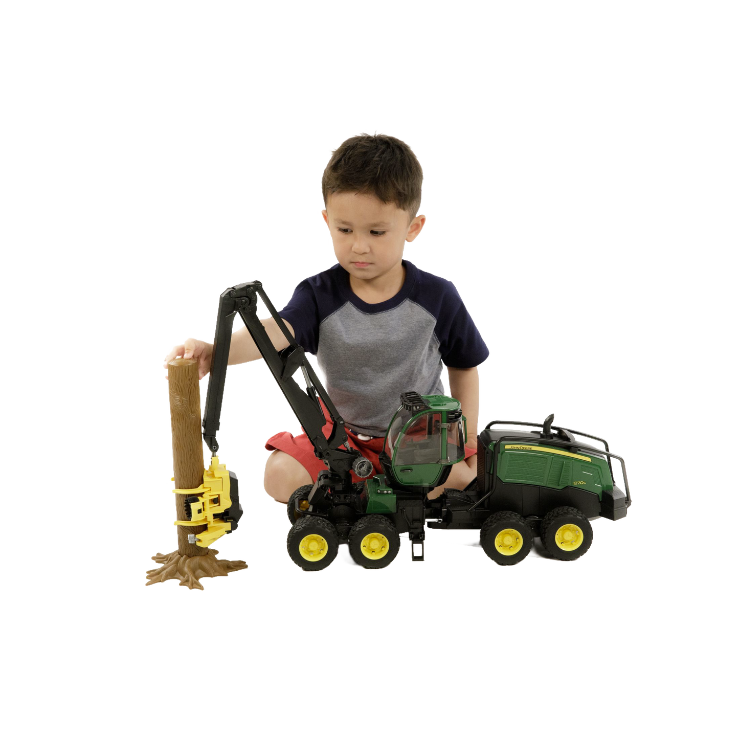 Child playing with green and yellow wheeled harvester toy lifting brown log from Bruder Toys collection